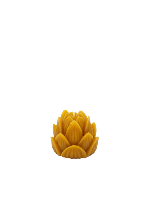 A small yellow-orange lotus-shaped decorative candle