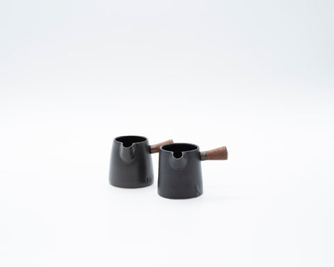 handmade black ceramic milk jug with small wooden handle